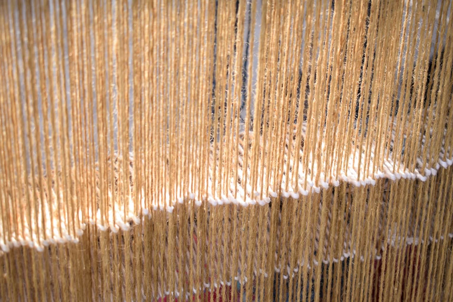 Golden jari threads on the workshop loom in Surat